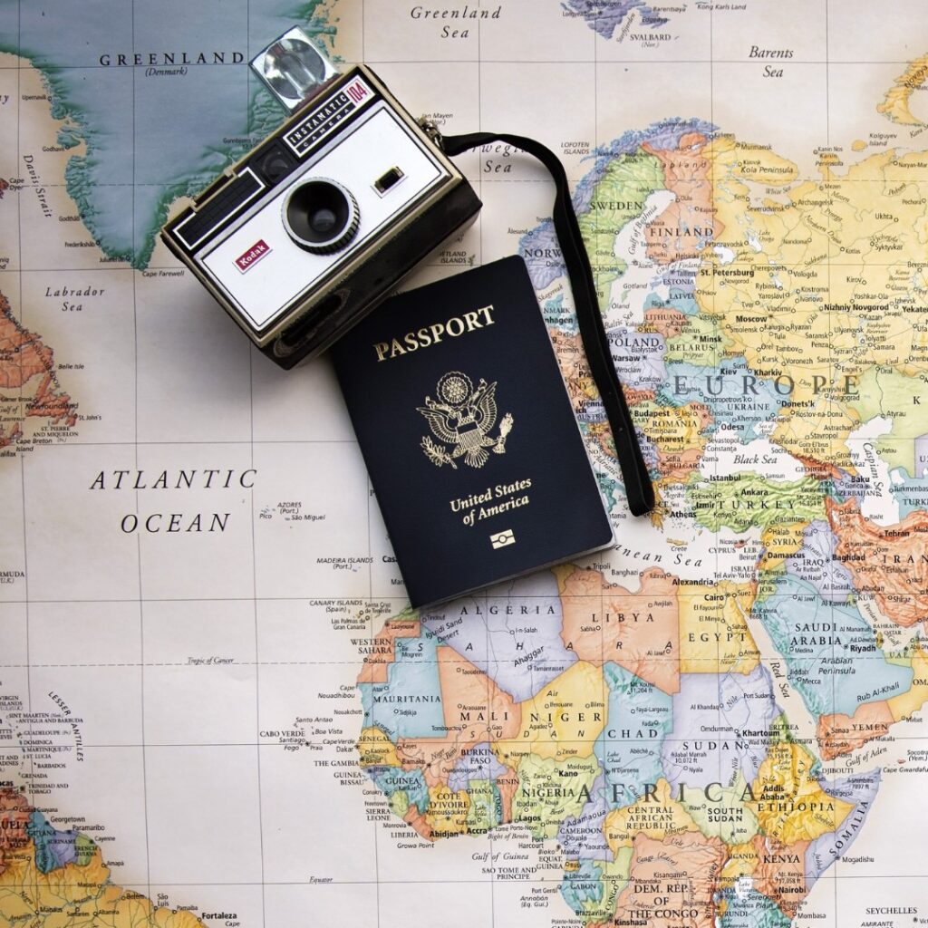 Camera, passport on a map for travel niche