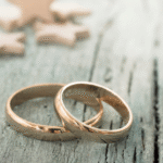 Two gold rings on a table . Wedding product image.